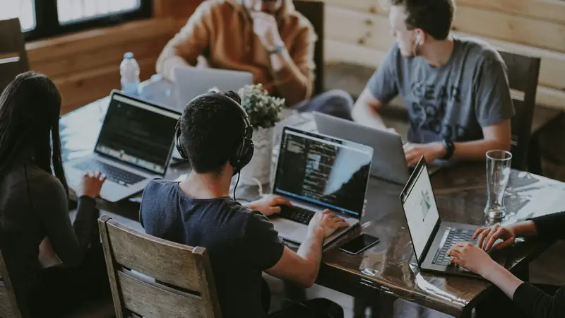 A team working together around a table with laptops